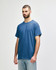 A blue Gildan Heavy Cotton adult t-shirt displayed on a model, featuring a simple design and a logo.