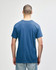 A blue Gildan Heavy Cotton Adult T-Shirt is displayed from the back, featuring a simple design and a logo.