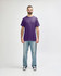 A purple Gildan Heavy Cotton Adult T-Shirt displayed on a model, paired with black jeans and casual shoes.