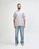 A grey Gildan Heavy Cotton adult T-shirt displayed on a male model wearing black pants and sneakers.
