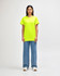 A man stands wearing a bright yellow Gildan Heavy Cotton Adult T-Shirt and black jeans, with sneakers.