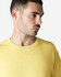 A yellow Gildan Heavy Cotton adult T-shirt, featuring a crew neck and a model displaying the side profile.