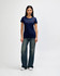A model wearing a navy blue Gildan Heavy Cotton Ladies' T-Shirt paired with blue jeans and white sneakers.