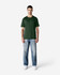 A green Gildan Softstyle adult T-shirt displayed on a model, paired with blue jeans and white shoes.