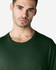 A green Gildan Softstyle adult T-shirt featuring a round neckline, modelled by a man.