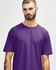 A man is wearing a purple Gildan Softstyle adult t-shirt, displaying a relaxed neckline and a casual style.