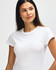 A white Gildan Softstyle ladies' T-shirt displayed on a model with a relaxed pose and a slight smile.