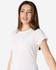 A white Gildan Softstyle ladies' T-shirt displayed on a model with a relaxed pose and a slight smile.