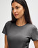 A grey ladies' t-shirt with a round neckline, featuring a logo on the sleeve. The model is looking directly at the camera.