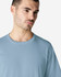 A light blue Gildan Softstyle adult midweight T-shirt featuring a crew neckline, displayed on a model.