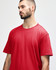 A red midweight t-shirt on a model, featuring a round neckline and short sleeves, displaying a minimalist design.