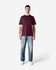 A maroon Gildan Softstyle adult midweight T-shirt displayed on a model, paired with black jeans and sneakers.