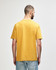 A midweight T-shirt in mustard yellow, featuring a plain back and a logo.
