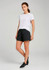 A woman models black sports shorts paired with a white t-shirt, standing against a neutral background.