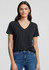 A woman wears a black short sleeve V-neck T-shirt paired with blue jeans, featuring a subtle logo.