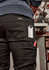 A pair of black stretch jeans with tool pockets and a ruler visible in one pocket, featuring a logo on the back.