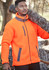 A man wearing an orange unisex full zip Sherpa fleece jacket, carrying a log over his shoulder.