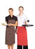 Two women wearing striped aprons, one in brown and the other in red, holding plates and trays.