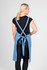 A full body denim apron in blue, featuring adjustable straps and a tied waist, displayed on a model from the back.