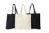 Three tote bags displayed: one black, one cream, and one black, featuring long handles and a simple design.