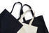 Three heavy tote bags in black and cream, featuring strap handles and a simple design. One bag has a logo.