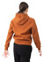 A woman wearing a rust-coloured hoodie with a kangaroo pocket, viewed from the back. The hoodie has a logo.