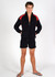 A man wearing a black and red unbrushed contrast track jacket, paired with black shorts and flip-flops.
