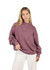 A model wearing a unisex stone wash sweatshirt in a muted mauve colour, with long sleeves and a relaxed fit.
