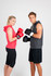 A red sleeveless hoodie worn by a woman and a grey sleeveless hoodie worn by a man, both holding boxing gloves.
