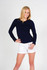 A woman wears a navy long sleeve T-shirt paired with white shorts, posing against a plain background.