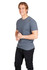 A grey heavy marl t-shirt on a smiling man, paired with black pants. The shirt features a logo.
