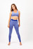 A model poses in a light purple seamless crop top and matching leggings, featuring a logo on the crop top.