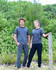 Brushed fleece pants in grey and black, featuring a logo, displayed by two models in an outdoor setting.