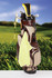 A bamboo golf towel in bright yellow hangs from a golf bag, surrounded by green grass and a blurred background of a golf course.