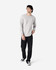 A long sleeve t-shirt in grey worn by a model, paired with black pants and sneakers, featuring a logo.