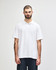 A white short-sleeve polo shirt on a model, featuring a collar and a logo.