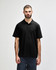 A model wearing a black Gildan Softstyle Adult Double Pique Polo with a logo on the chest.