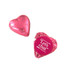 A pink chocolate heart wrapped in shiny foil, accompanied by a decorative foil wrapper with a logo.