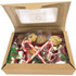 A kraft gift box filled with assorted candies, cookies, and decorative candy canes in red, green, and gold.
