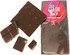A block of dark chocolate with several pieces broken off, featuring a round branding logo.