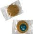 A round, light brown cookie packaged in clear plastic, featuring a logo on the front.
