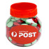 A clear plastic jar filled with red and green chocolate beans, featuring an orange lid and a logo.