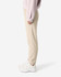 Unisex sweatpants in a light beige colour, featuring a logo, styled with a pink top and white sneakers.