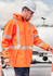 A heavy-duty waterproof jacket in bright orange with reflective stripes, worn by a person wearing a safety helmet.