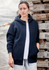 A navy unisex zip front hoodie with multiple pockets, worn by a woman against a backdrop of wooden pallets.