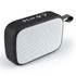 A rectangular black and white portable speaker with a textured surface and a carrying strap.