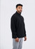 A black polar fleece half zip top worn by a male model, styled with grey pants, featuring a logo.
