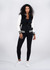A women's wool blend varsity jacket in black and white, featuring a zip front and striped cuffs, alongside black leggings.
