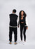 A black and cream varsity jacket worn by a woman and a man, featuring a logo on the back.