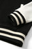 A black and white varsity jacket featuring a ribbed collar and cuffs. A logo is visible on the jacket.